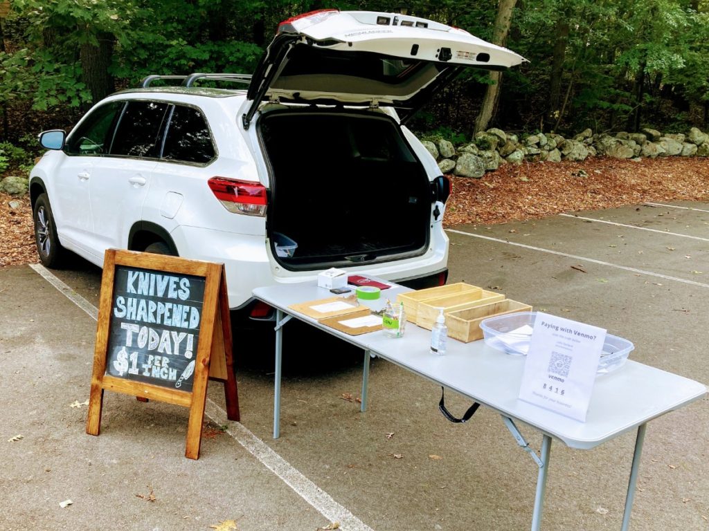 table set up to pickup customer's kitchen knives in a parking lot